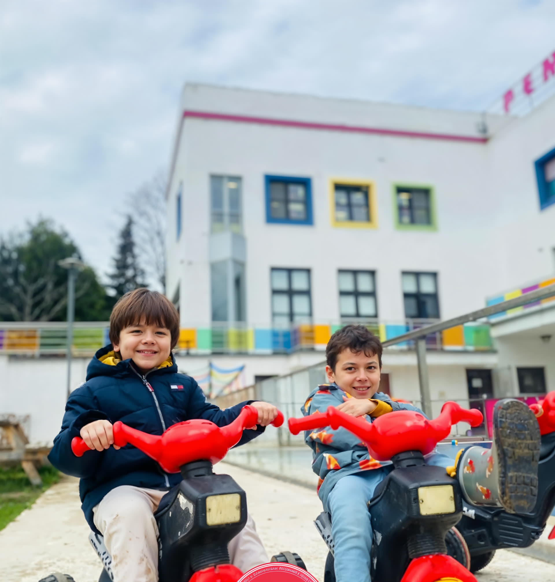 Okul bahçesinde oyuncak traktörlerde iki çocuk
